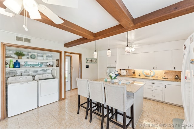 904 N Morningside Dr, Vinita, OK 74301 - kitchen featuring beam ceiling, visible vents, backsplash, ceiling fan, and washer and dryer