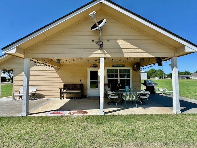 rear view of house featuring a yard and a patio area