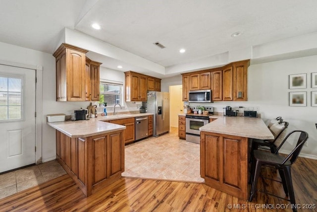35041 Cohea Ln, Ketchum, OK 74331 - kitchen with brown cabinets, stainless steel appliances, light countertops, a sink, and a peninsula