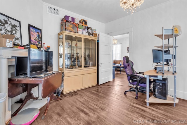 home office with wood finished floors, visible vents, an inviting chandelier, and crown molding