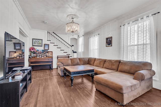 living room featuring hardwood / wood-style floors, a chandelier, and crown molding