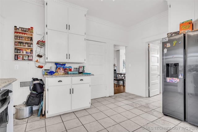 kitchen featuring white cabinets, stainless steel refrigerator with ice dispenser, ornamental molding, and light tile patterned floors