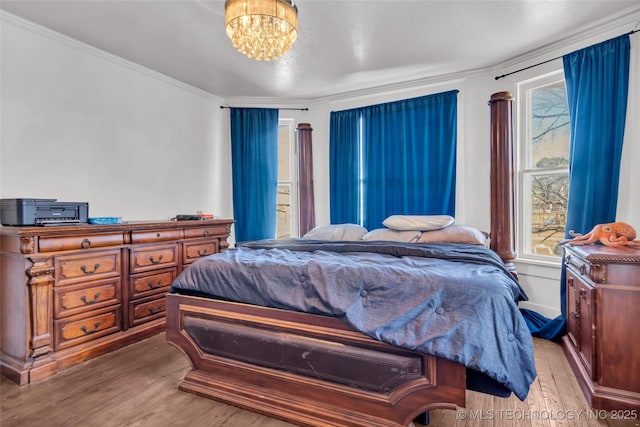bedroom with wood finished floors, a chandelier, and multiple windows