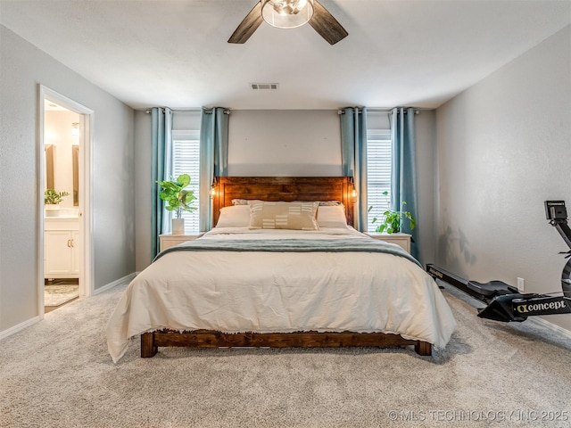 carpeted bedroom with visible vents, connected bathroom, a ceiling fan, and baseboards