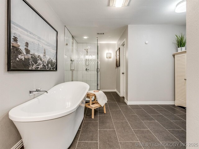 full bath with a freestanding tub, a stall shower, visible vents, baseboards, and tile patterned flooring