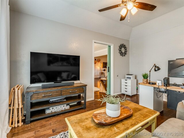 living room featuring a ceiling fan, vaulted ceiling, wood finished floors, and baseboards