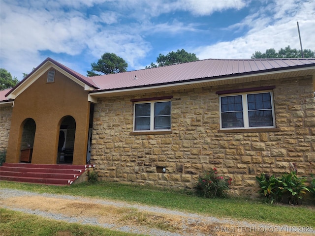 view of front facade featuring stone siding and metal roof
