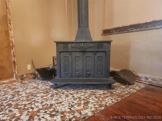 interior details with wood finished floors and a wood stove