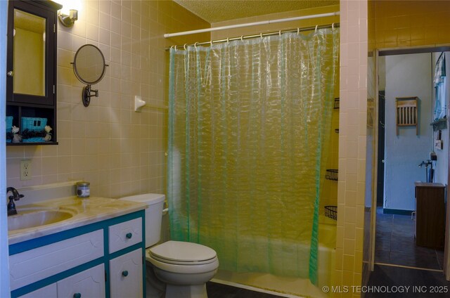 full bath featuring vanity, tile walls, toilet, tile patterned flooring, and shower / bath combo with shower curtain