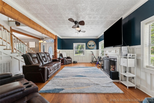 living area with a ceiling fan, an ornate ceiling, crown molding, a fireplace, and visible vents