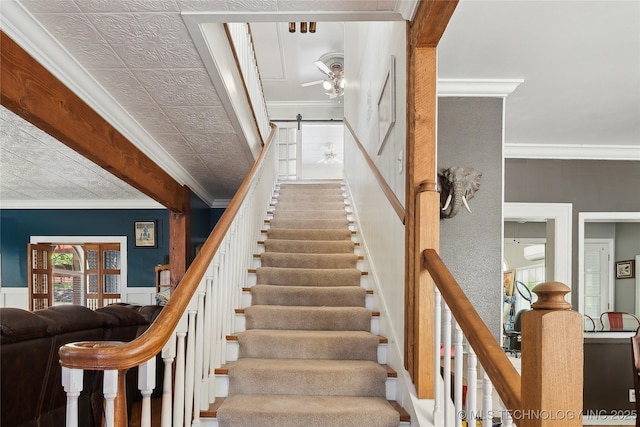 stairs with a barn door, an AC wall unit, crown molding, and a wainscoted wall