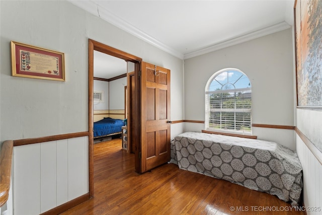 bedroom with crown molding and wood finished floors