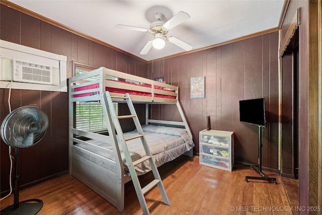 bedroom featuring wood finished floors and crown molding