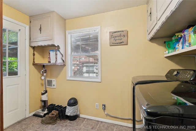 laundry area featuring washing machine and dryer, baseboards, tile patterned flooring, and cabinet space