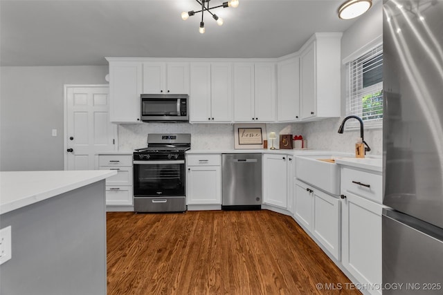 507 W Quincy St, Broken Arrow, OK 74012 - kitchen featuring stainless steel appliances, a sink, light countertops, dark wood-type flooring, and backsplash