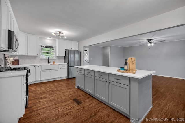 507 W Quincy St, Broken Arrow, OK 74012 - kitchen with stainless steel appliances, gray cabinets, a sink, ceiling fan, and dark wood-style flooring