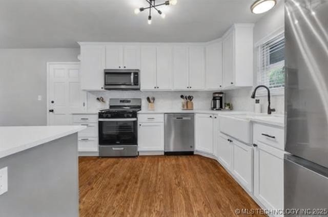 507 W Quincy St, Broken Arrow, OK 74012 - kitchen featuring appliances with stainless steel finishes, a sink, light countertops, dark wood-style floors, and white cabinetry