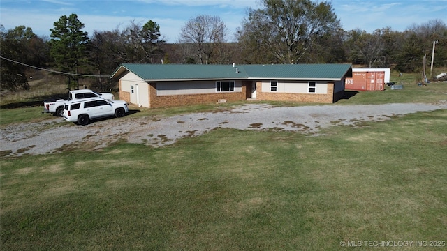 view of front of property featuring a front lawn and metal roof