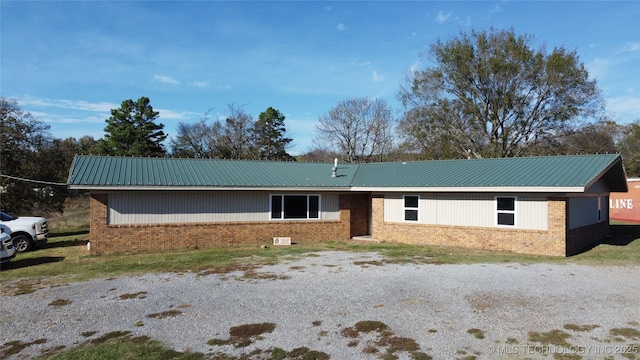 single story home featuring brick siding and metal roof