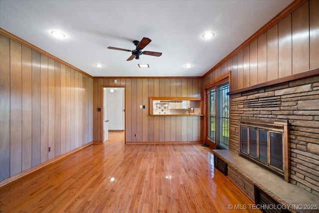 509 NE 10th St, Wagoner, OK 74467 - unfurnished living room with light wood finished floors, baseboards, ceiling fan, a stone fireplace, and ornamental molding