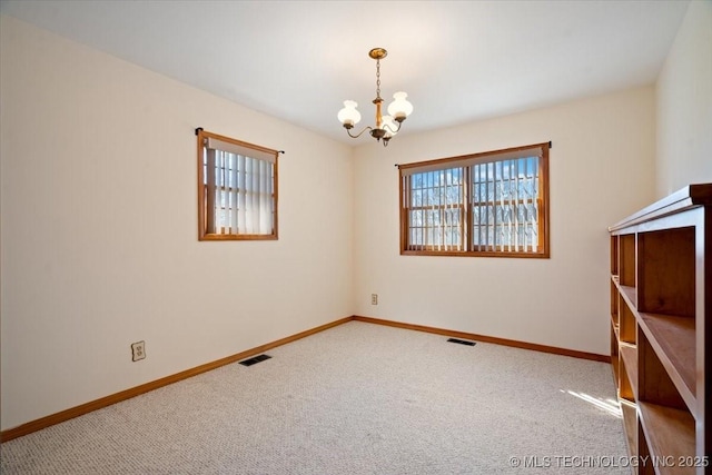 509 NE 10th St, Wagoner, OK 74467 - spare room featuring carpet, visible vents, baseboards, and a notable chandelier