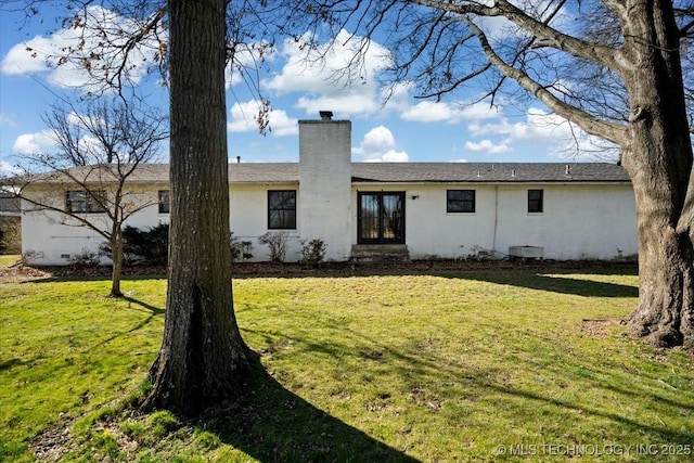 509 NE 10th St, Wagoner, OK 74467 - back of house with french doors, a lawn, and a chimney