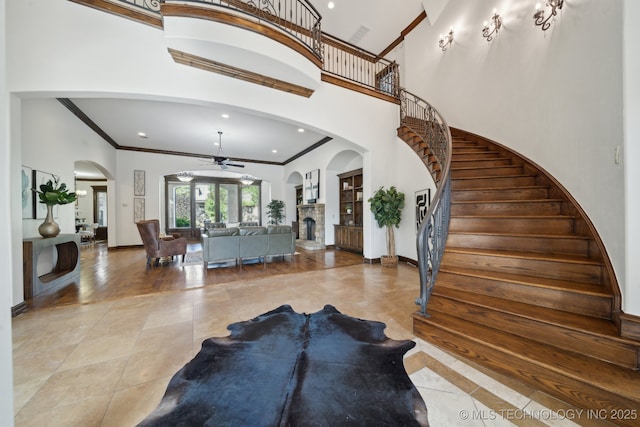 10626 S Joplin Ave, Tulsa, OK 74137 - entrance foyer with ceiling fan, ornamental molding, stairs, baseboards, and a fireplace with raised hearth