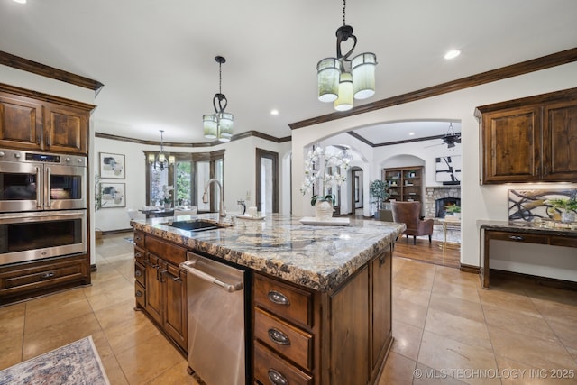 10626 S Joplin Ave, Tulsa, OK 74137 - kitchen with stainless steel appliances, a chandelier, a sink, arched walkways, and a stone fireplace