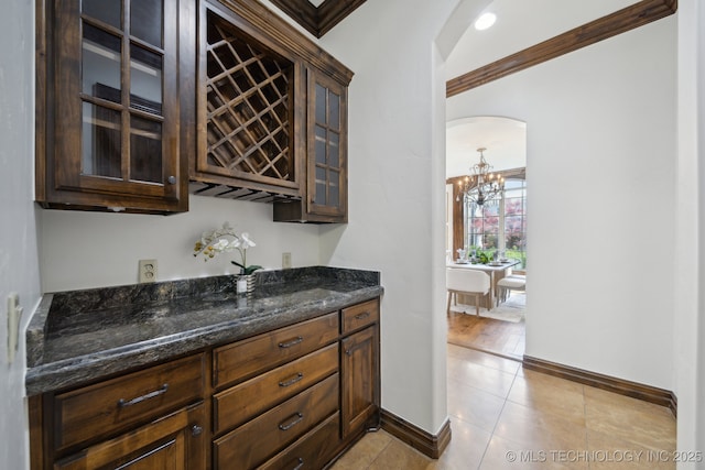 10626 S Joplin Ave, Tulsa, OK 74137 - indoor dry bar with arched walkways, ornamental molding, a chandelier, baseboards, and light tile patterned flooring