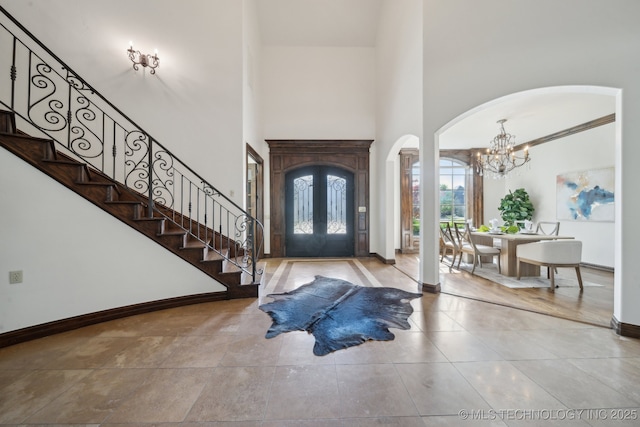 10626 S Joplin Ave, Tulsa, OK 74137 - entryway featuring arched walkways, a chandelier, stairway, baseboards, and a high ceiling