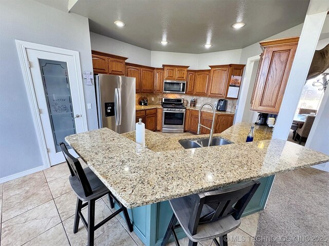 1412 Richmond Dr, Fort Gibson, OK 74434 - kitchen with stainless steel appliances, a breakfast bar, a sink, a peninsula, and brown cabinetry