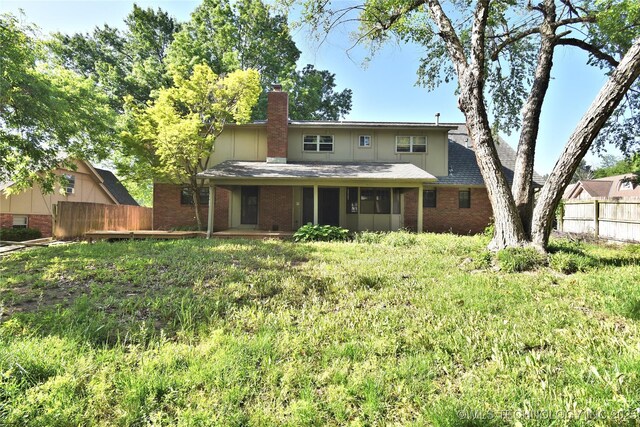 6903 E 63rd St, Tulsa, OK 74133 - back of property featuring fence, brick siding, a chimney, and roof with shingles
