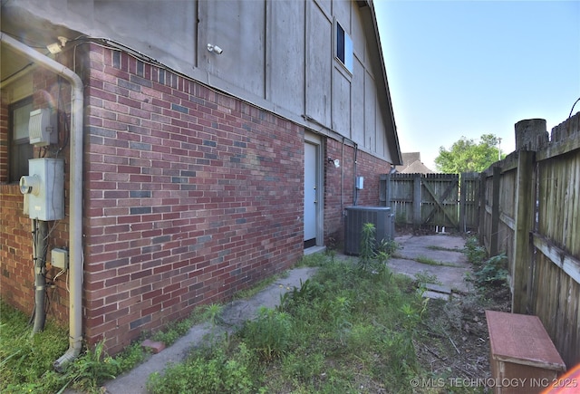 6903 E 63rd St, Tulsa, OK 74133 - view of side of home featuring brick siding, fence, and central AC