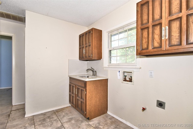 6903 E 63rd St, Tulsa, OK 74133 - clothes washing area featuring hookup for an electric dryer, hookup for a washing machine, cabinet space, a textured ceiling, and baseboards