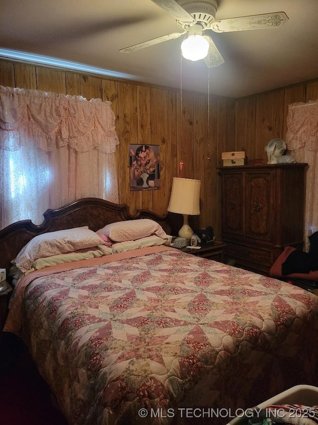 bedroom featuring wooden walls and ceiling fan