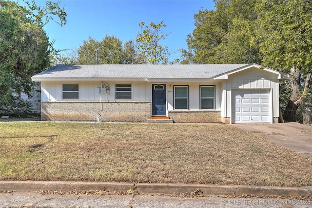 ranch-style house featuring board and batten siding, brick siding, a front yard, and a garage