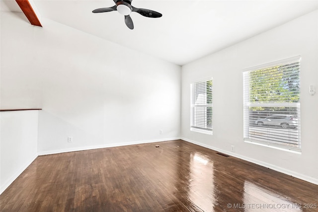 empty room featuring wood finished floors, visible vents, a ceiling fan, and baseboards