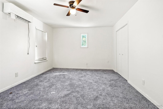 unfurnished bedroom with baseboards, carpet floors, a ceiling fan, and a wall unit AC