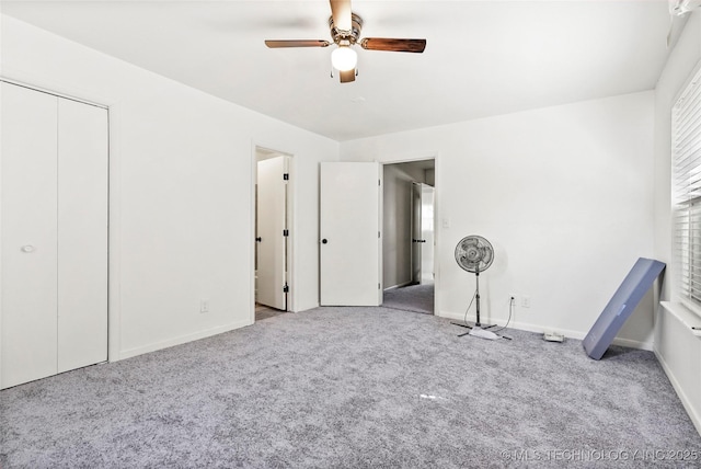 unfurnished bedroom with carpet floors, a ceiling fan, and baseboards