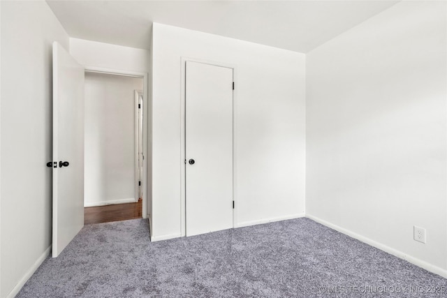 unfurnished bedroom featuring baseboards and carpet