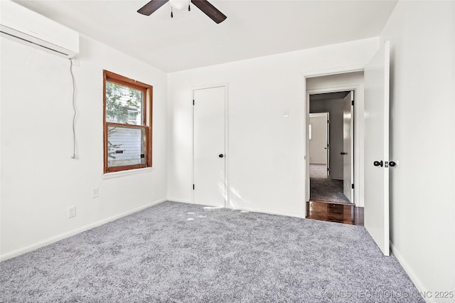 unfurnished bedroom featuring an AC wall unit, baseboards, carpet flooring, and ceiling fan