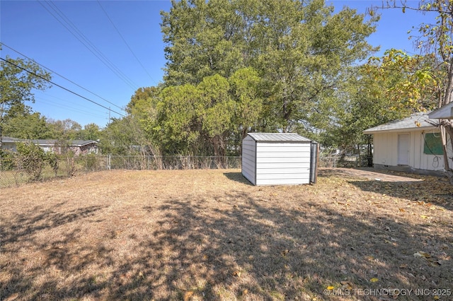 view of yard featuring a storage unit, an outbuilding, and a fenced backyard