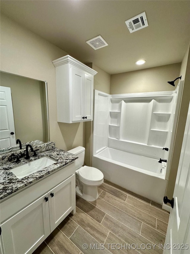 full bath featuring washtub / shower combination, wood finish floors, visible vents, and vanity
