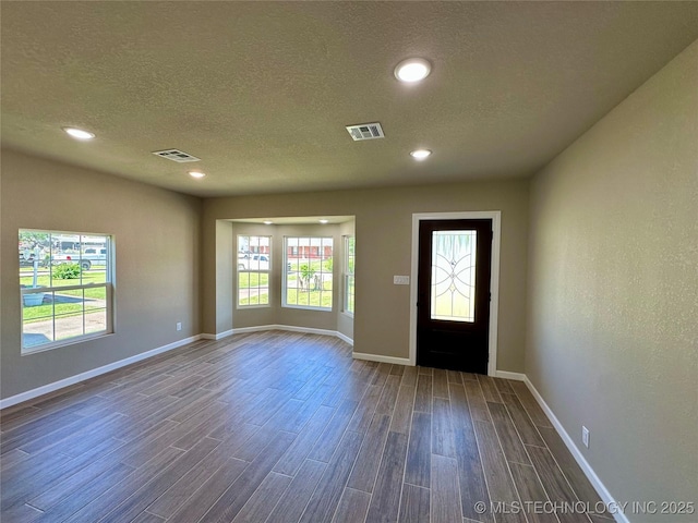 foyer with recessed lighting, visible vents, baseboards, and dark wood-style flooring