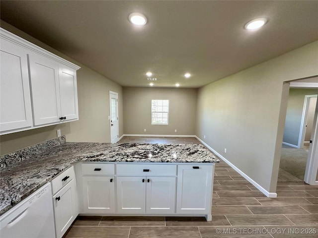 kitchen with a peninsula, white dishwasher, recessed lighting, and white cabinetry
