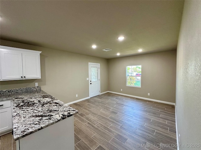 kitchen with wood finished floors, baseboards, white cabinetry, visible vents, and recessed lighting