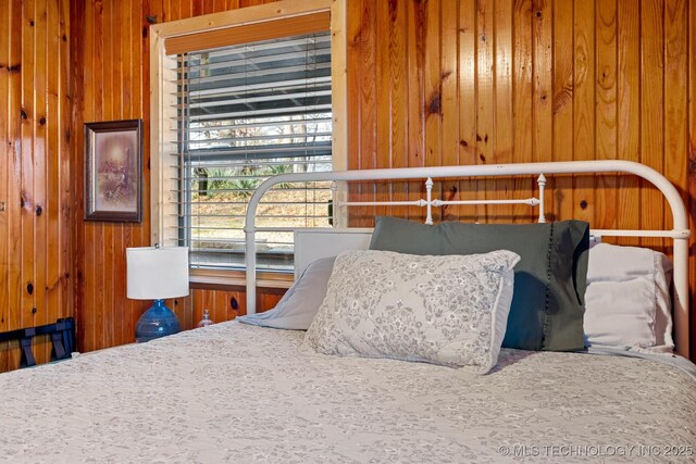 bedroom featuring wooden walls