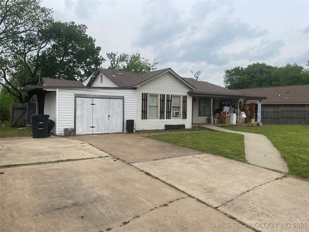 back of property with fence, a lawn, driveway, and roof with shingles