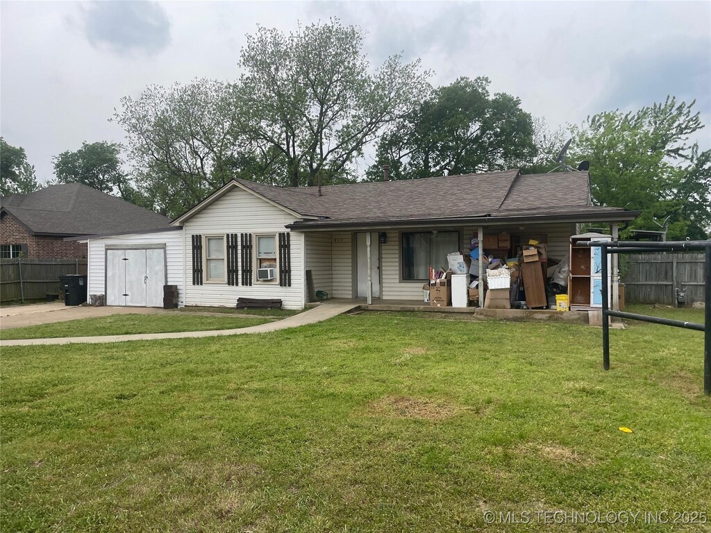 rear view of property featuring a porch, a lawn, a shingled roof, and fence