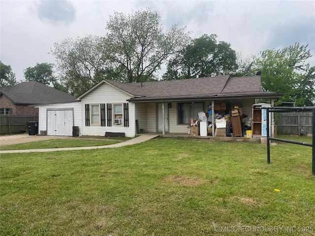 rear view of property featuring a porch, a lawn, a shingled roof, and fence